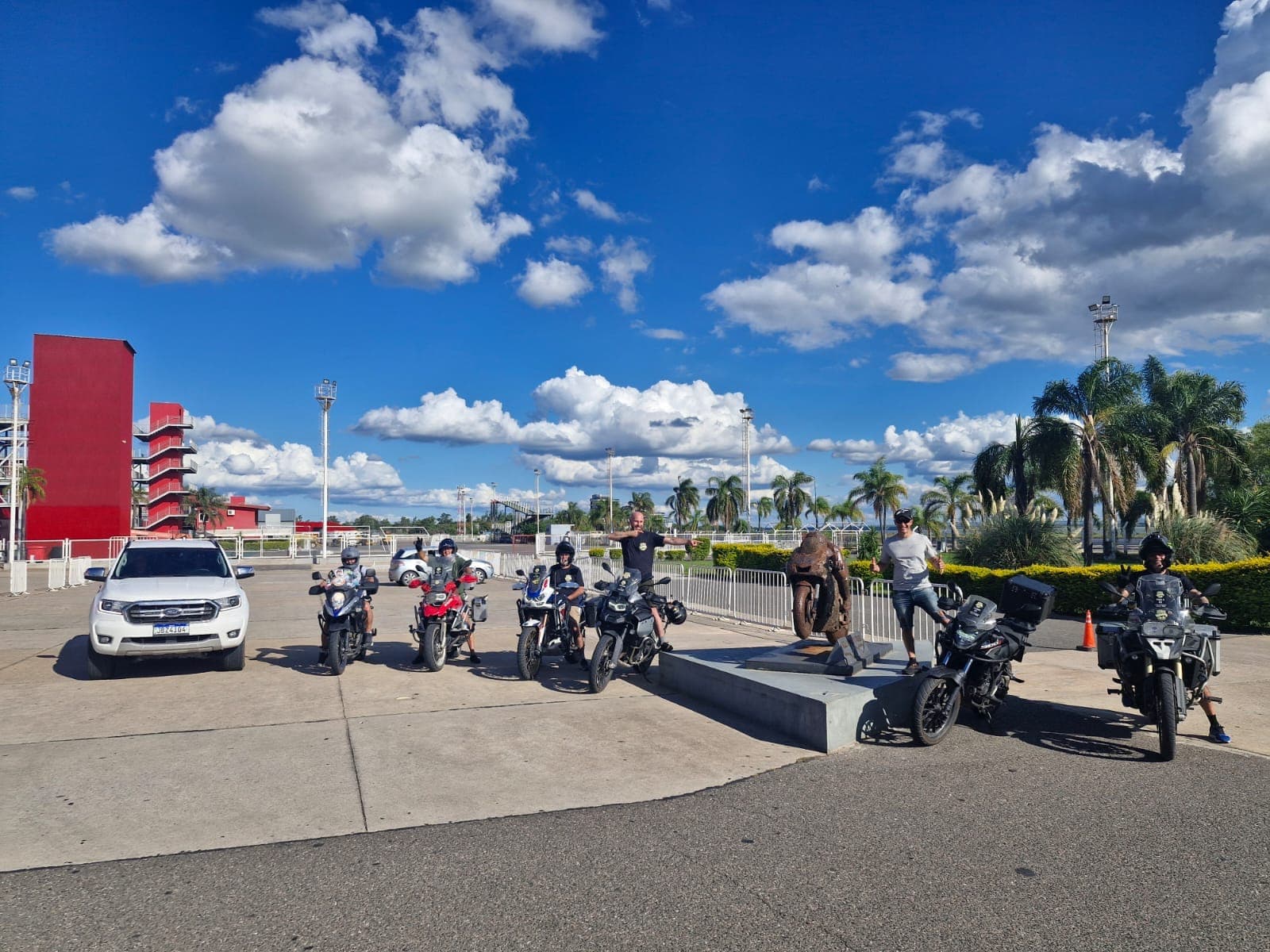 Motos do grupo e a caminhonete de apoio estacionadas no autódromo de Termas de Río Hondo, sob céu azul